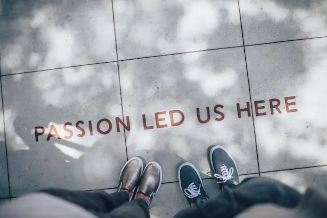 Zwei Personen stehen auf einem Gehweg mit der Aufschrift 'Passion led us here' – Symbol für Purpose und Storytelling.